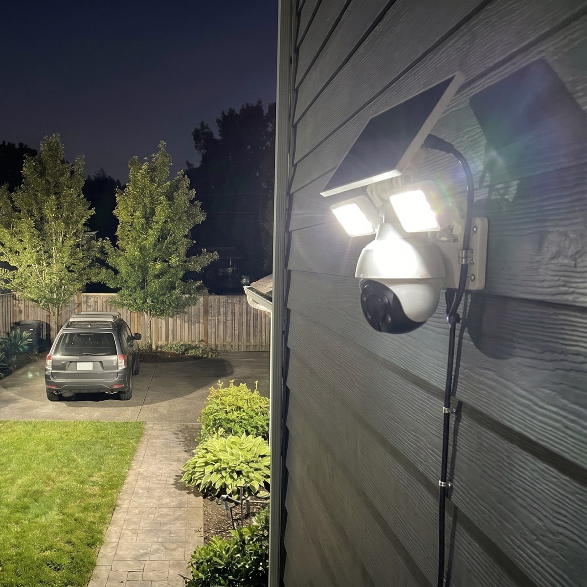 The two LED floodlights above the camera light up the driveway and the garden at night